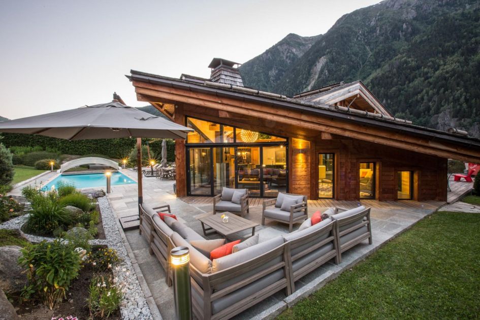 Chalet Couttet offers a great option to explore Chamonix in autumn. Here, we see the side of the property and outdoor space surrounding the chalet, including a furnished terrace and outdoor swimming pool.