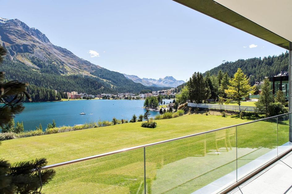 The Loft Apartment in St Moritz features stunning views of Lake St Moritz which can be seen from its terrace (as pictured here) - beautiful blue waters can be found after a patch of green grass in front of the apartment, with mountains protruding in the distance.