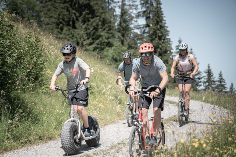A family riding Trotti Bikes on a Swiss Alps summer holiday in Gstaad.