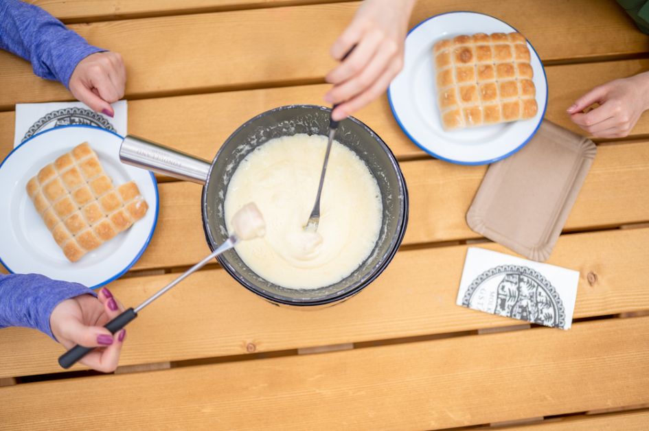 Eating traditional cheese fondue in Gstaad on a summer holiday in the Swiss Alps.