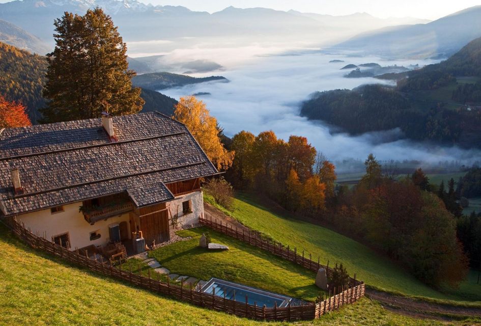 Exterior, outdoor spa area, and gardens of San Lorenzo Lodge in Brunico, overlooking the mountain views in summer.