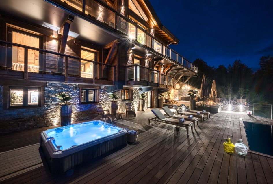 Mont des Anges, Morzine Luxurious outdoor hot tub next to numerous loungers that overlook the distant forest, mountain views. Also, a seating area for alfresco dining.