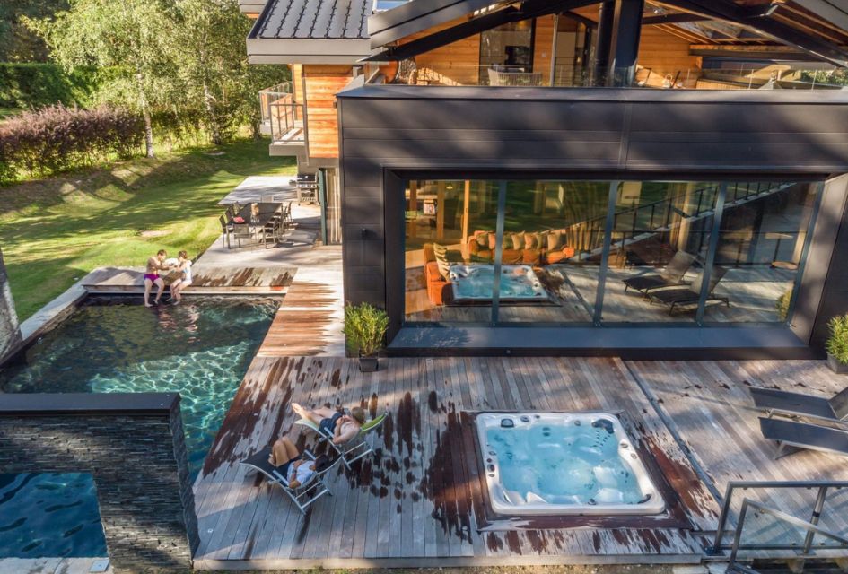 Chalet Dalmore, Chamonix The spacious terrace that boasts a BBQ, alfresco dining and various wellness facilities, people enjoying the loungers in the sun.