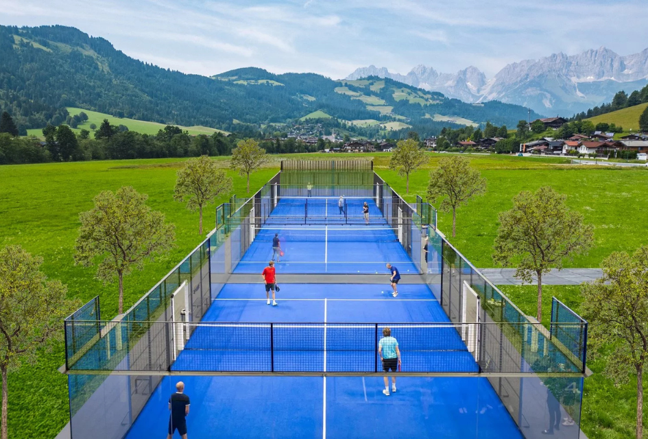 Padel courts situated in a peaceful setting surrounded by summer greenery and mountain scenery in Kitzbühel.