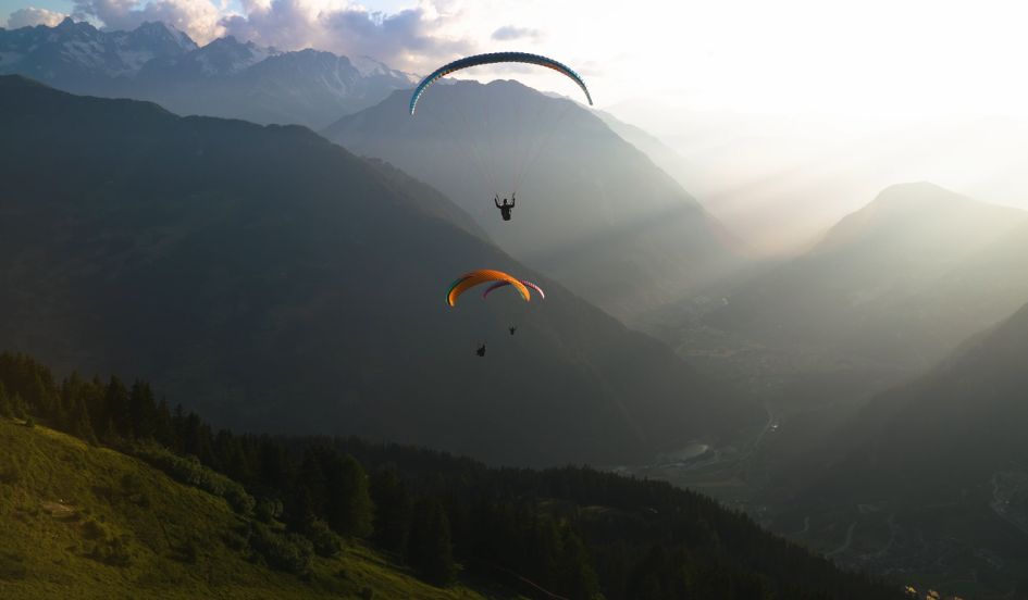 Paragliding, The Lodge A small group paragliding above the mountain landscape on a luxury summer holiday in Verbier