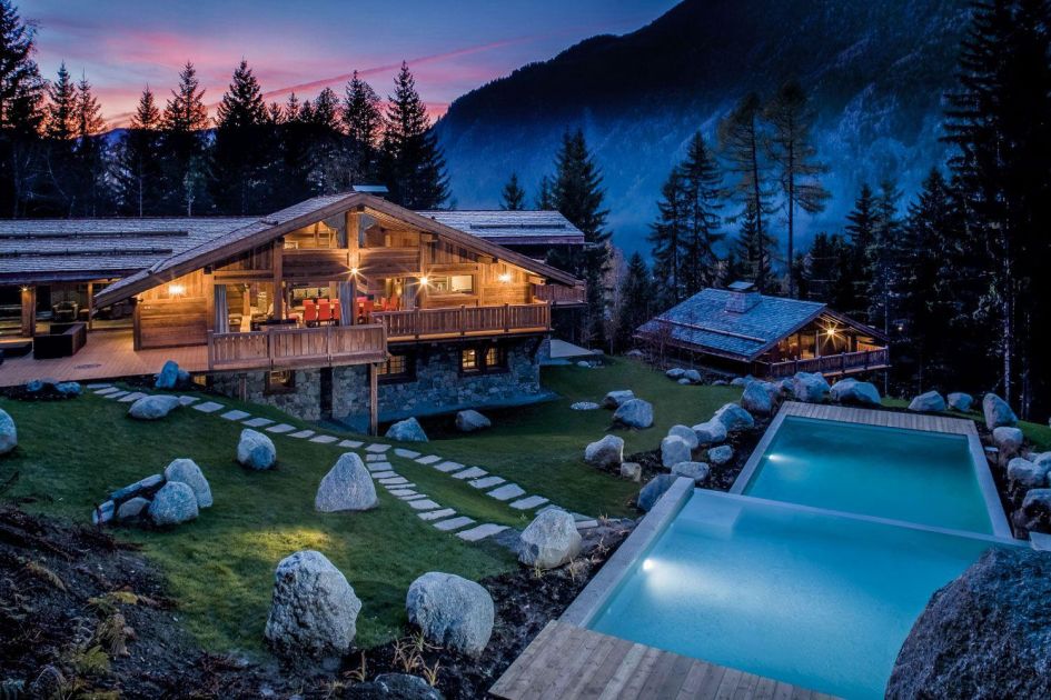 External view of Chalet Amazon Creek during night-time, showcasing its incredible outdoor split level swimming pool.