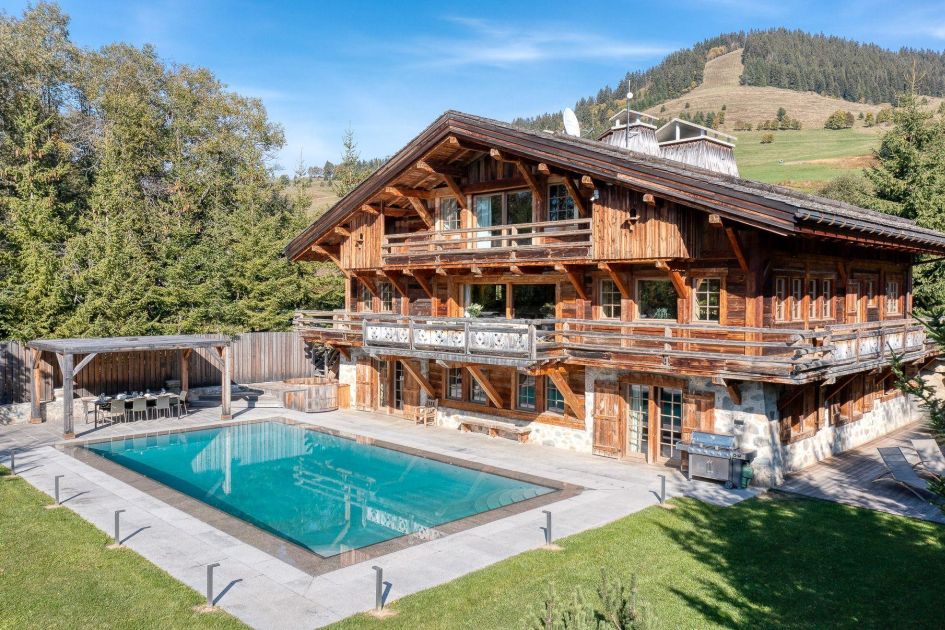 A shaded alfresco dining spot at Chalet Izoard in Megève, positioned next to the immaculate outdoor swiming pool.