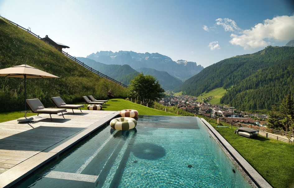 Perched on a hillside. Chalet Lum d'Or's outdoor swimming pool offers stunning views of the mountains ahead.