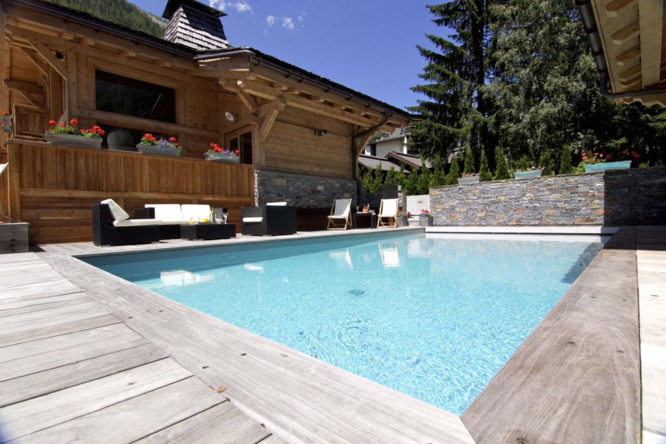 Casual seating arrangements along one side of the outdoor swimming pool for relaxing, social afternoons.