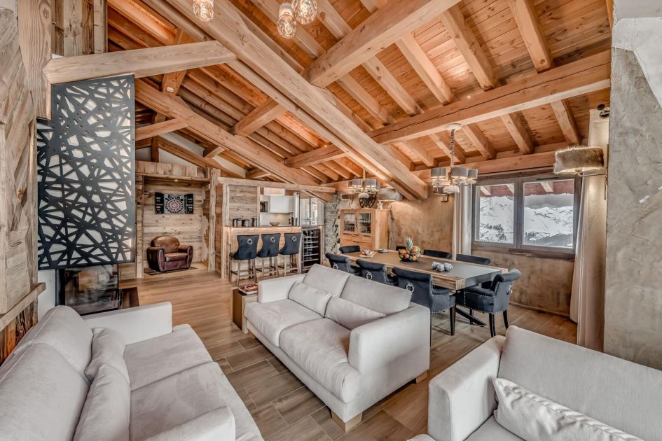 Annapurna Lodge Macha, Tignes Open-plan living space featuring plush sofas, traditional dining table and rustic kitchen.